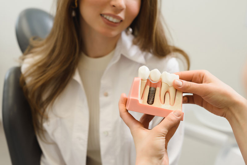 Dental Patient Getting Shown A Dental Implant Model During Her Consultation in Albuquerque, NM